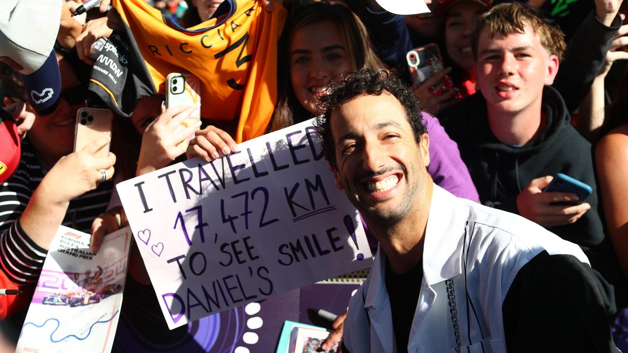 MELBOURNE, AUSTRALIA – MARCH 22: Daniel Ricciardo of Australia and Visa Cash App RB poses for a photo with a fan holding a banner on the Melbourne Walk prior to practice ahead of the F1 Grand Prix of Australia at Albert Park Circuit on March 22, 2024 in Melbourne, Australia. (Photo by Peter Fox/Getty Images)