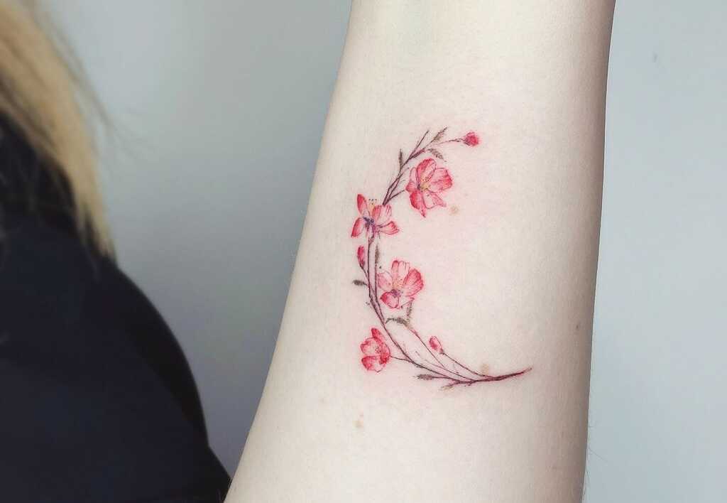 A woman's arm with tattoo of cherry blossom  flowers 