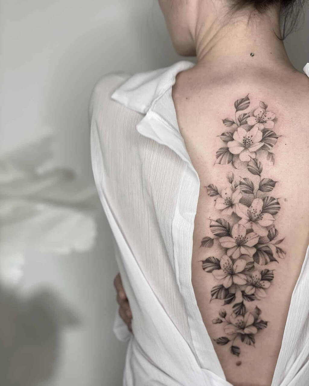A woman with a cherry blossom tattoos  on her back
